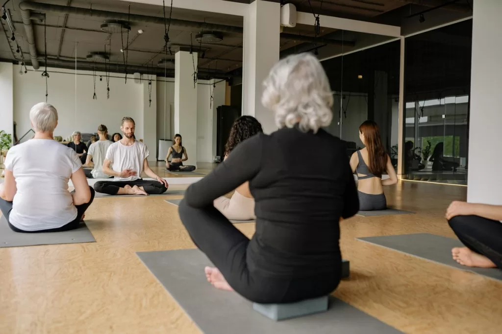 um curso de yoga presencial em um estúdio com várias pessoas.