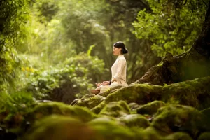 Uma mulher fazendo hatha yoga na natureza.