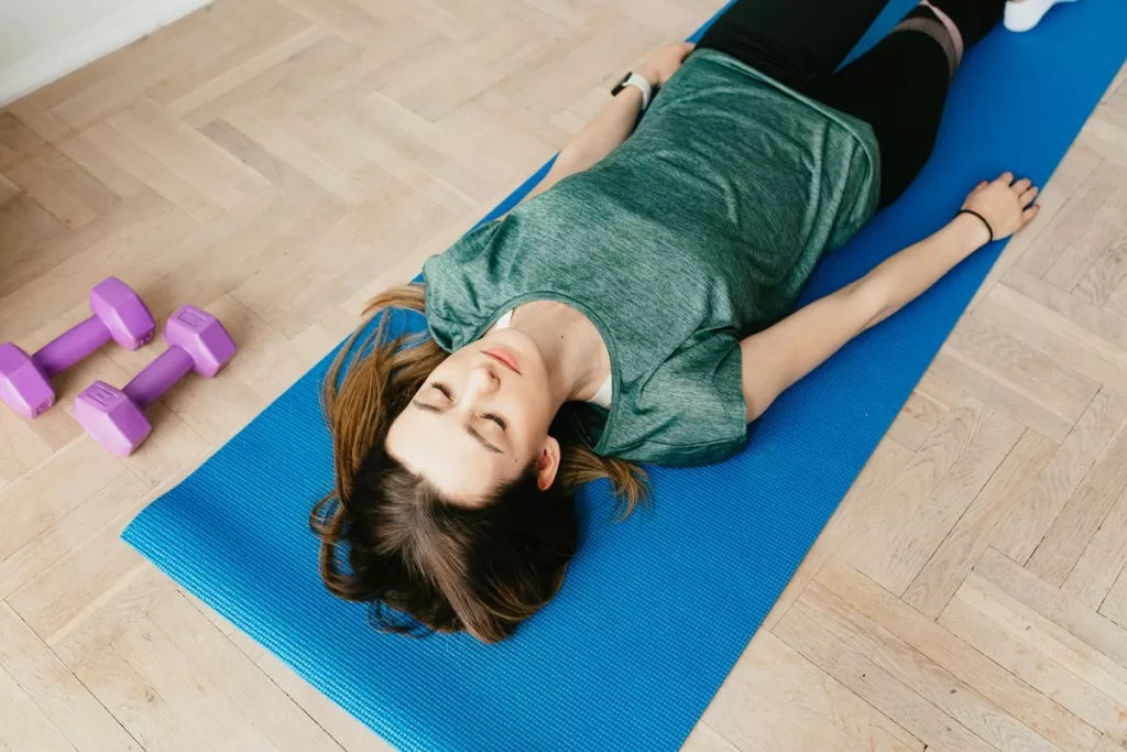 Uma mulher praticando yoga antes de dormir em um tapete de yoga.