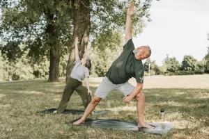 duas pessoas ao ar livre praticando yoga para dois